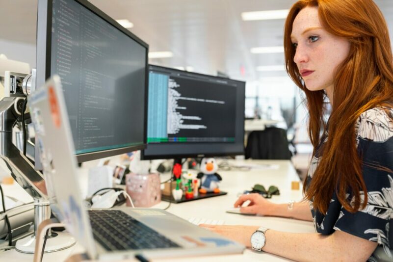 Woman working at a computer on coding software